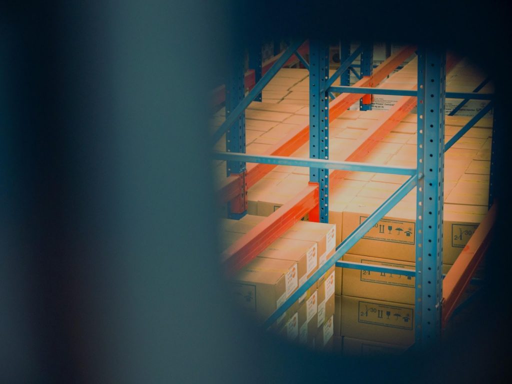 Close-up of cardboard boxes stacked on industrial warehouse shelving racks.